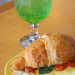 croissant tomate manjericão e queijo com soda italiana ao fundo